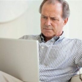 Business casual man looking at a laptop